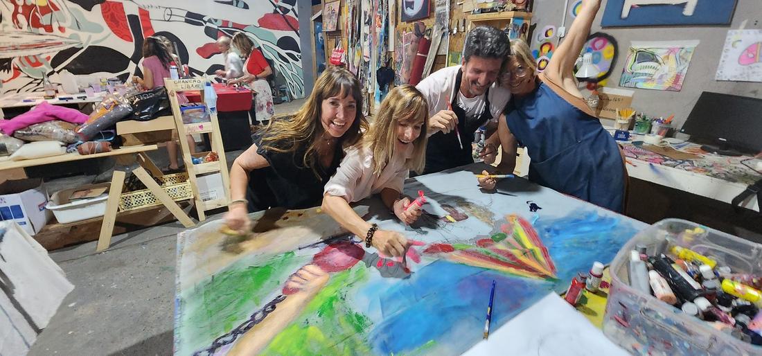 Personas pintando en las mesas del taller